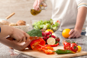 Cutting a vegetables for a salad with an olive oil