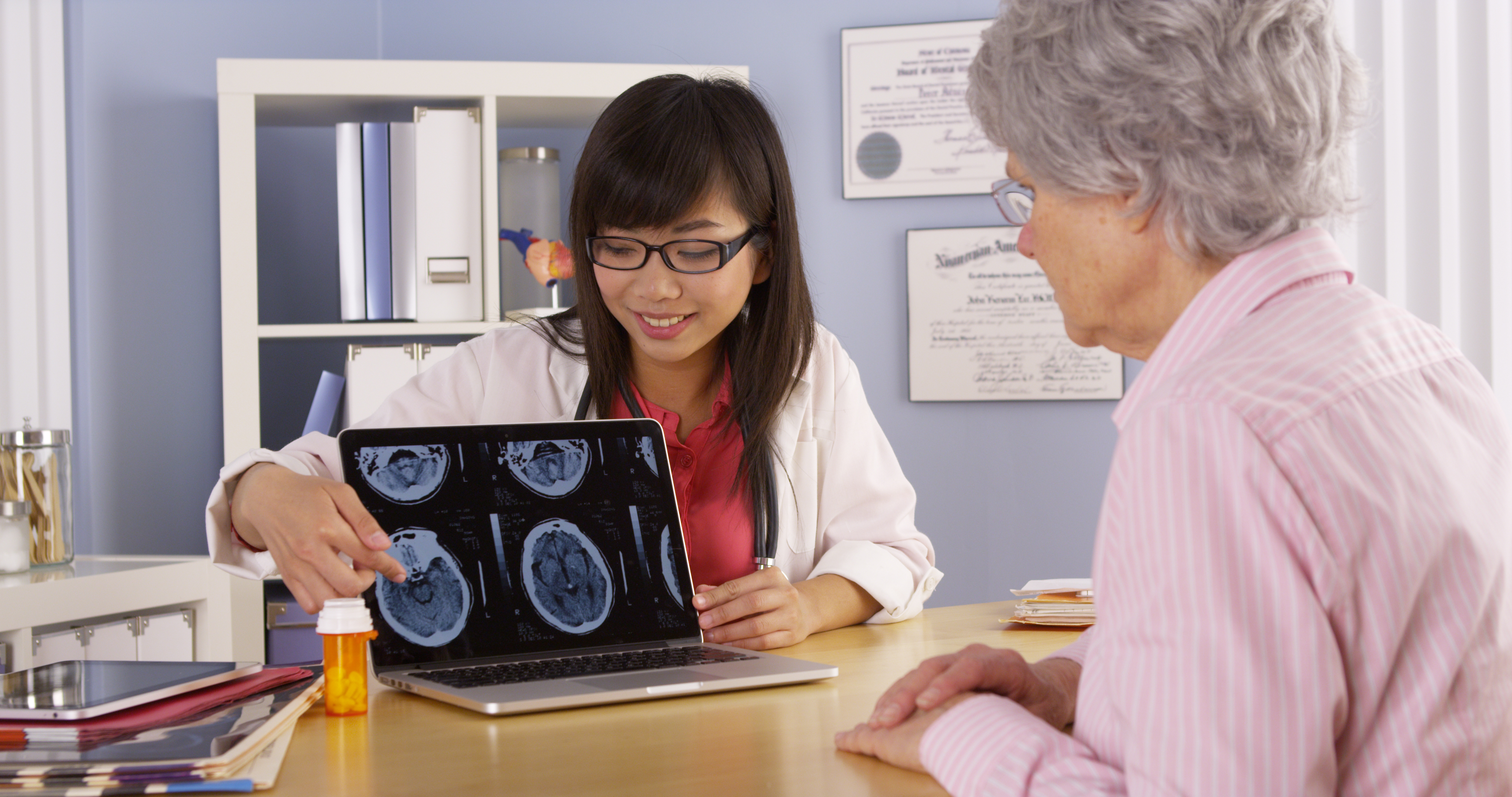 Doctor explaining brain scans to elderly patient