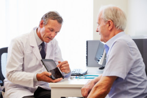 A senior patient sits with a doctor