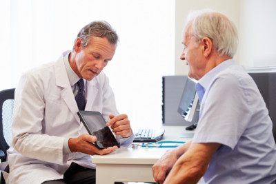 A senior patient sits with a doctor