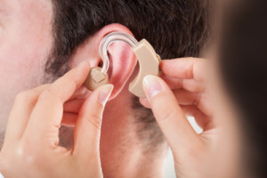 Hearing aid being place in patients ear