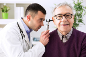 A senior man gets an ear exam at the doctor's office
